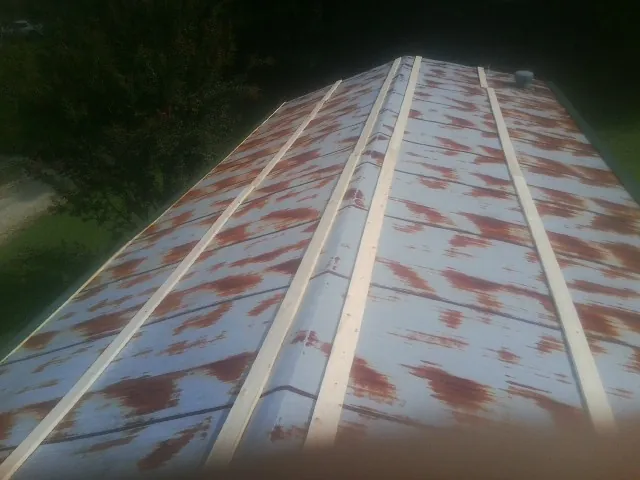 Rusted metal roof panels with new wood purlins before replacement — Storm Damage Roof Repair in West Milton by Roofing Brothers