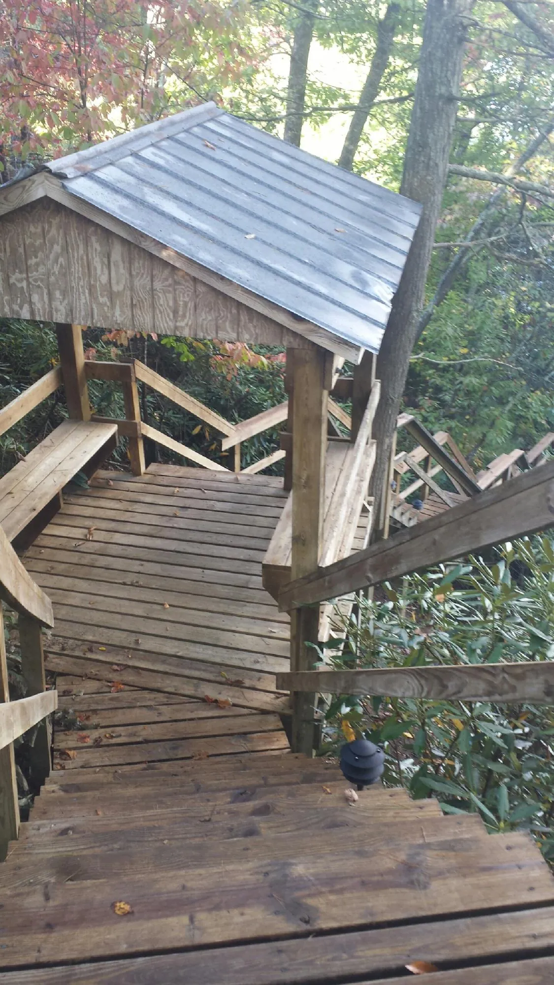 Metal roofed shelter over wooden steps on a wooded walkway — Skylight Repair & Installation work by our crew in West Milton